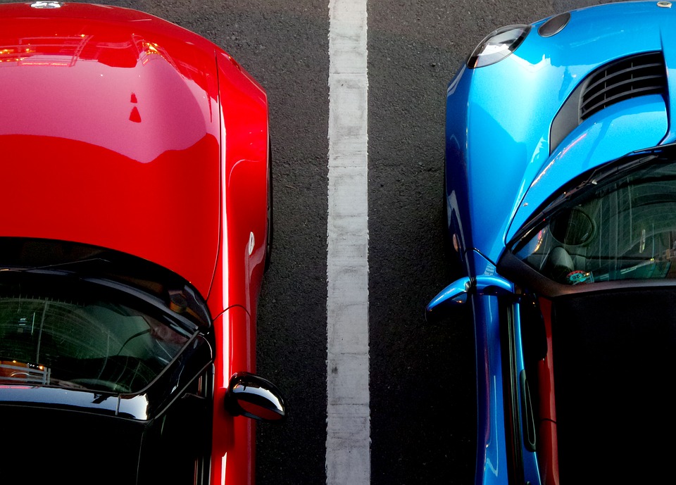 Rød og blå bil på parkeringsplads