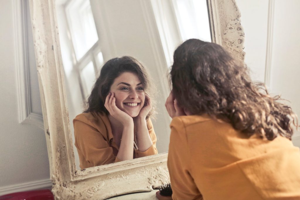 Kvinde smiler til spejl