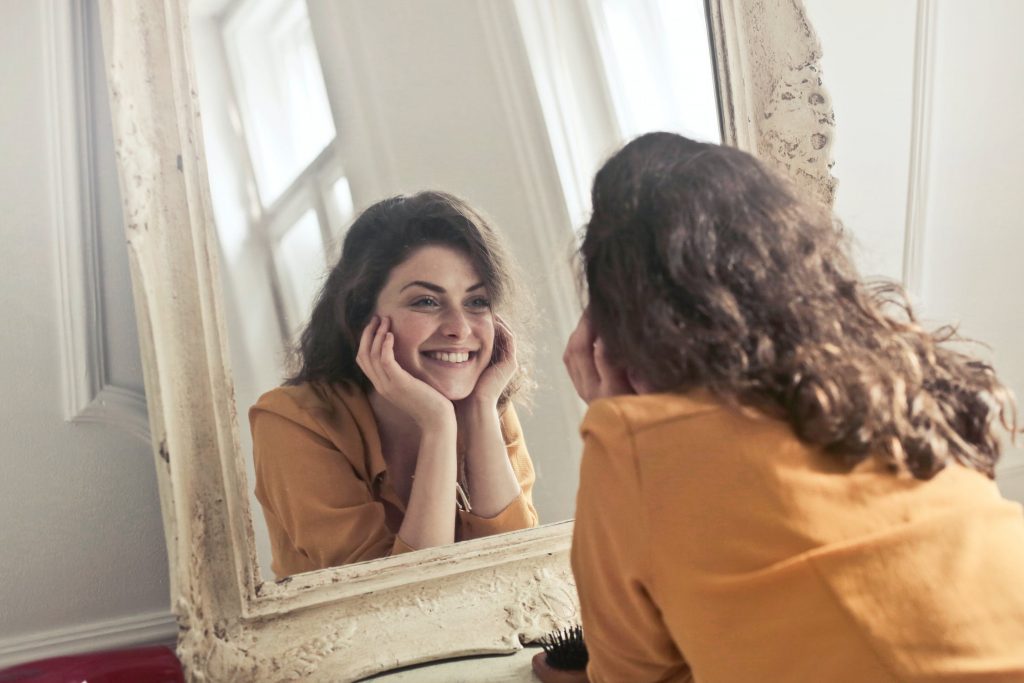 Kvinde smiler i spejl